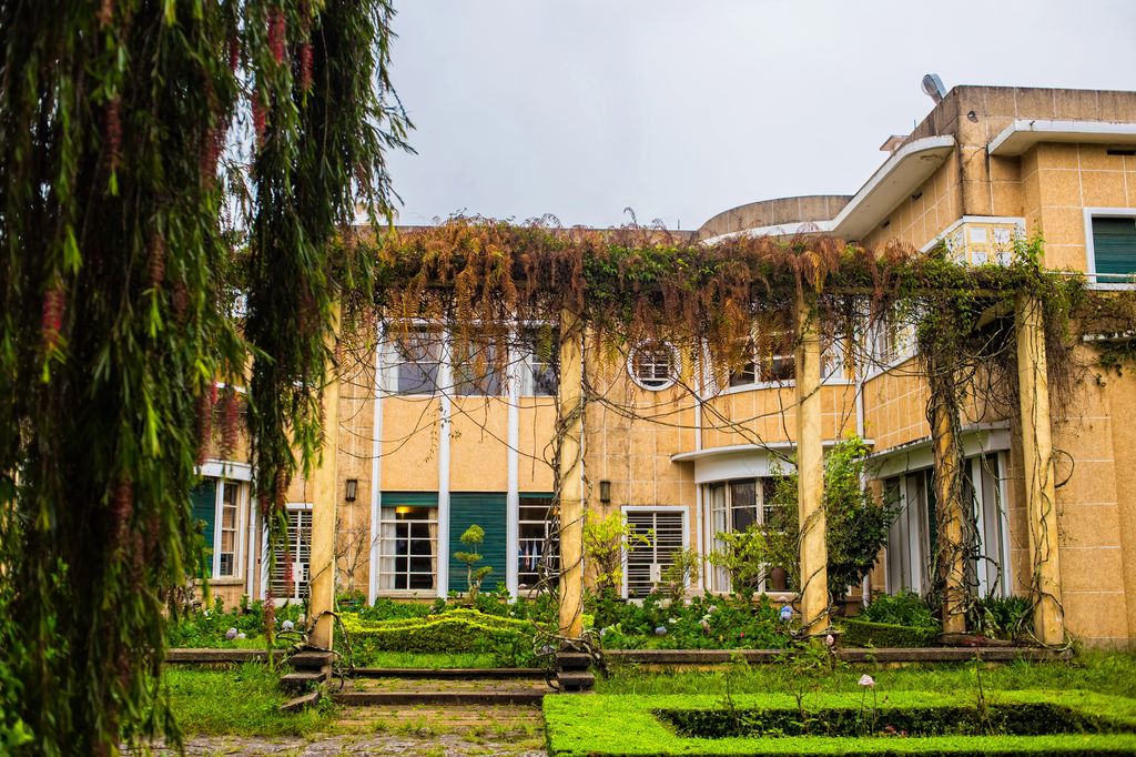 A yellow building surrounded by bushes and vines in Dalat, Vietnam.