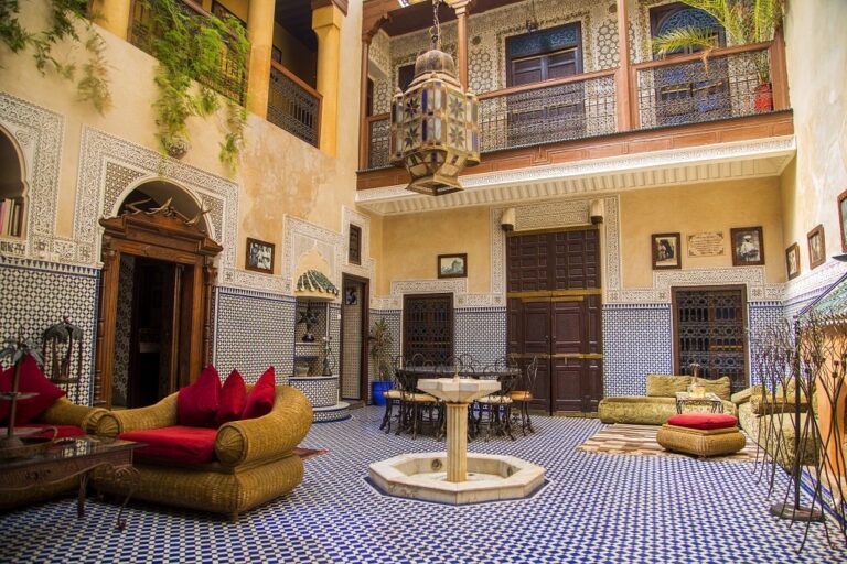 The outdoor area, with a fountain, chairs, and tables, in the middle of a riad in Marrakech