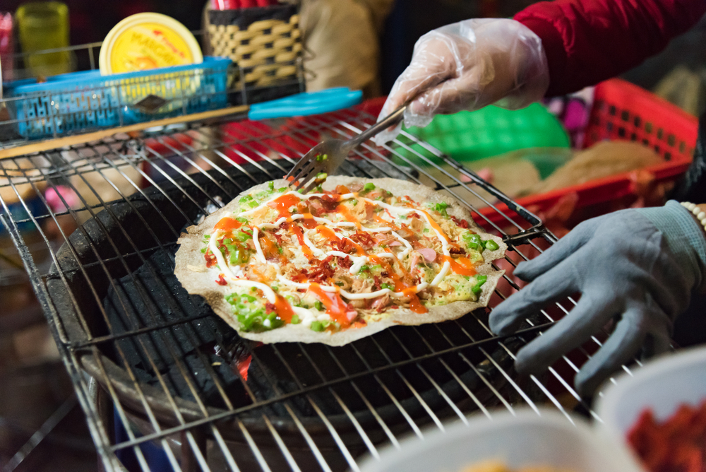 Banh xeo rice pancakes being grilled in Dalat, Vietnam.