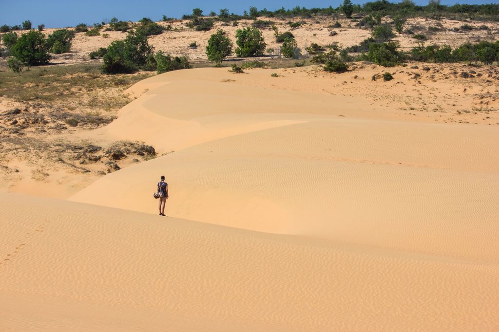 A person standing in a desert in Phan Thiet, Vietnam.
