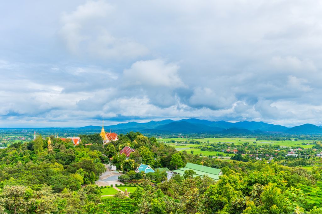 Trees, some buildings, and mountains in Doi Saket, Chiang Mai, Thailand.