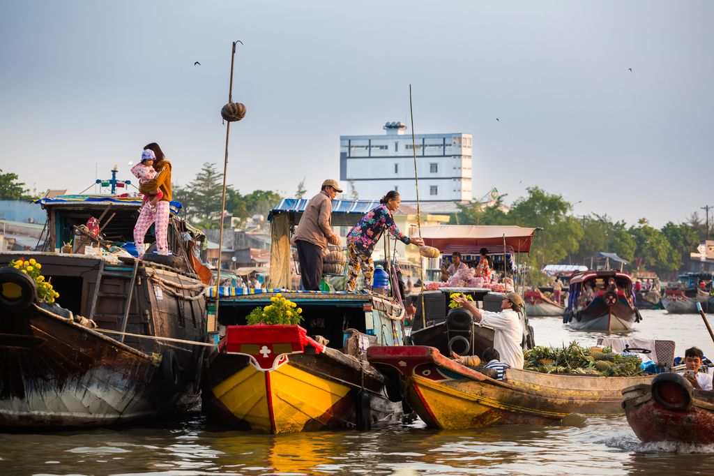 People selling and buying goods at a floating market in Can Tho, Vietnam.