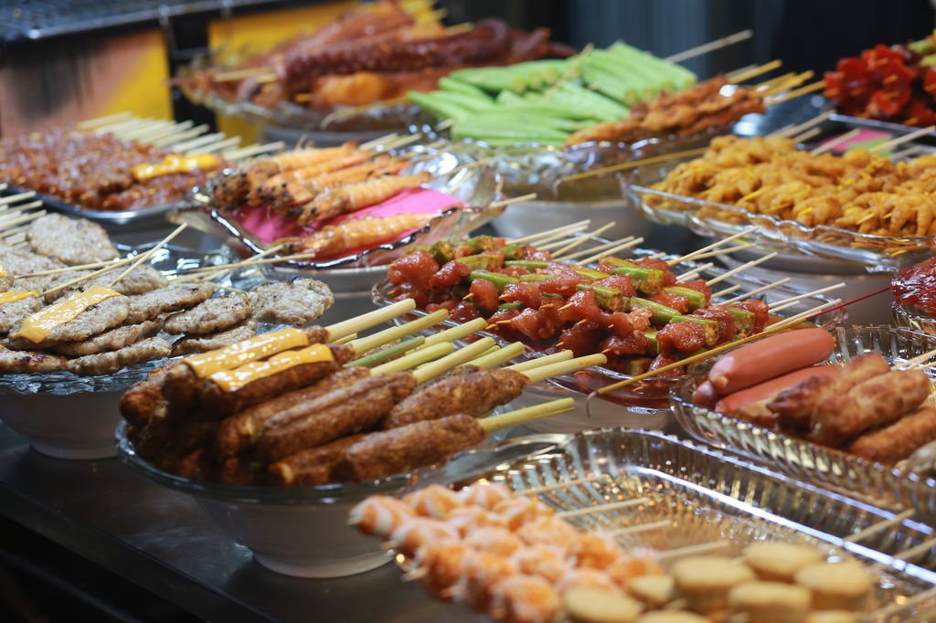 Grilled food on sticks at a street food market in Saigon, Vietnam.