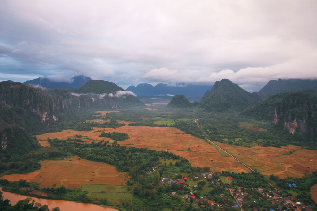 An aerial view of a rural town on a cloudy day in Laos.