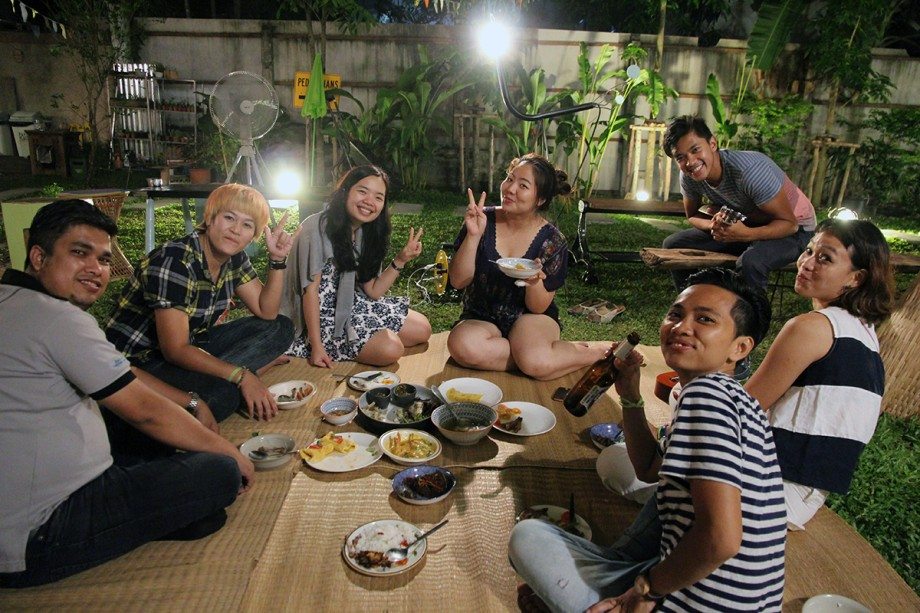 People having a picnic outdoors at nighttime in Thailand.