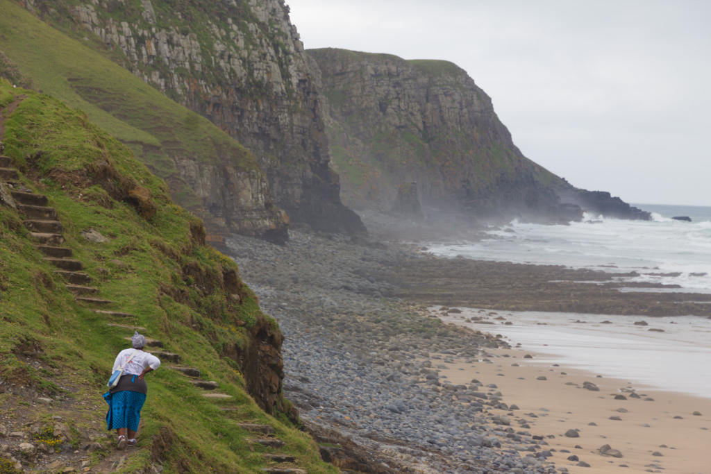 Woman in traditional clothes walking along the coast near Coffee Bay in South Africa