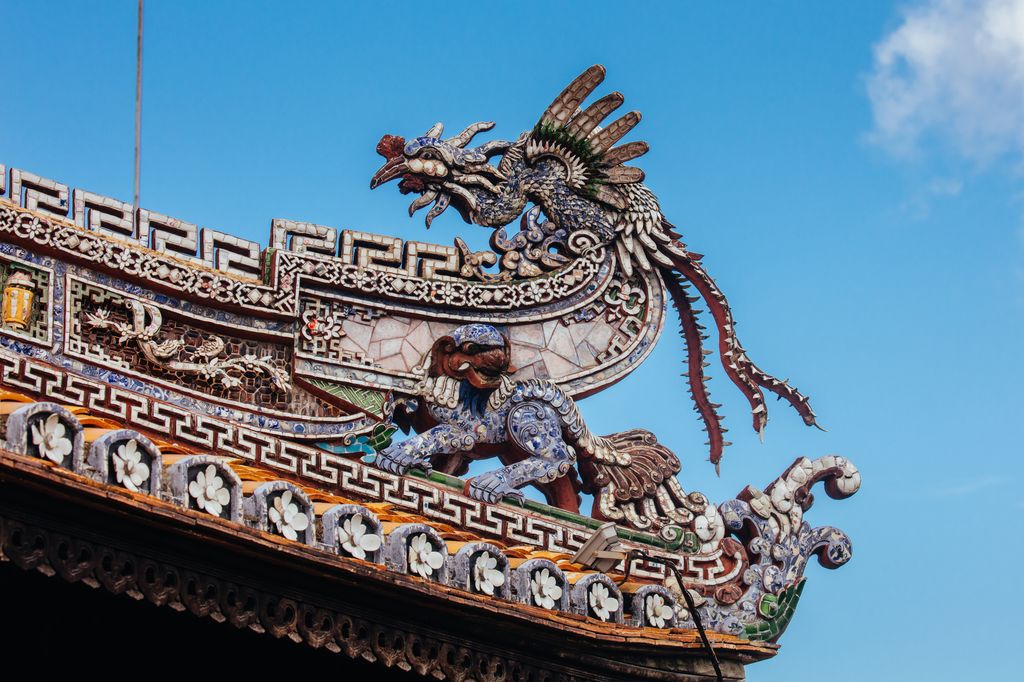 Dragon architecture detail on the roof of the Imperial Citadel in Hue, Vietnam under the blue sky.