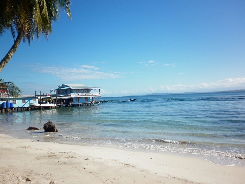 The beach at Isla Carenero in Bocas del Toro with blue sky and blue sea.