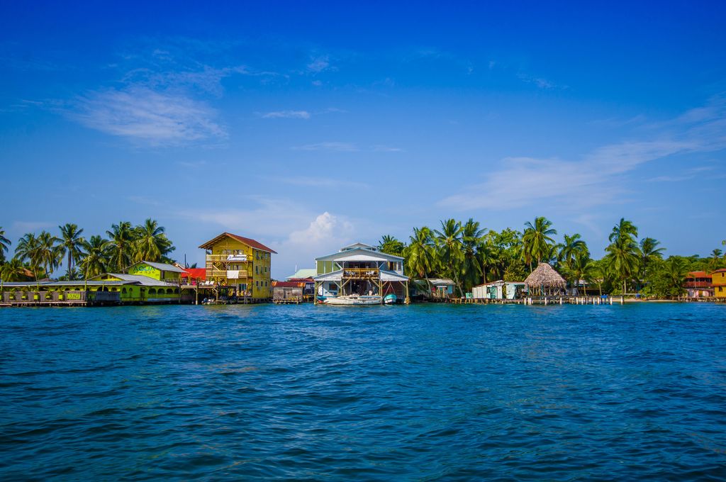 Houses and trees between blue sky and blue sea in Bocas del Toro, Panama.