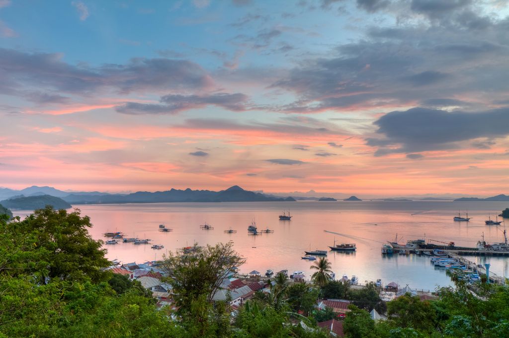 The port of Labuan Bajo in Flores, Indonesia under blue and pink skies.