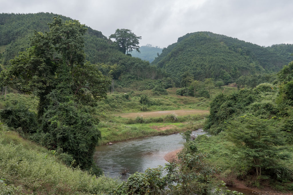 A river surrounded by trees and hills in Luang Namtha, Laos.