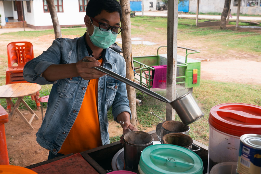 A man making food outdoors in Luang Namtha, Laos.