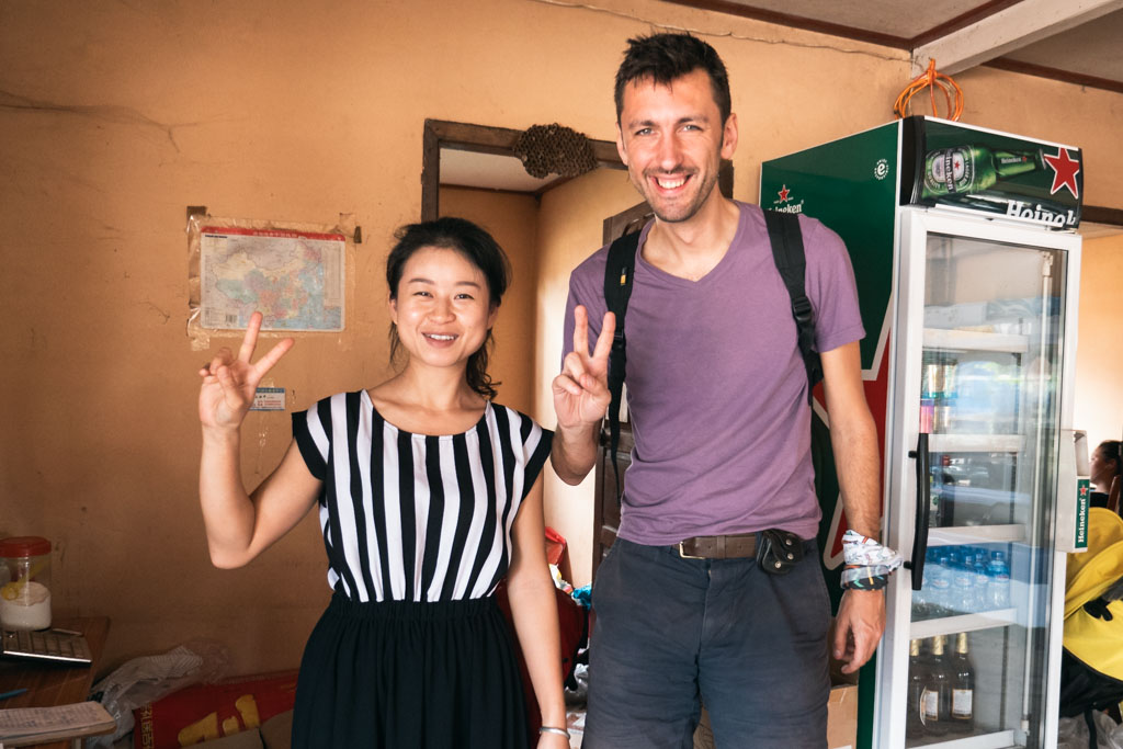 A woman and a man posing with their right hands doing a peace sign.