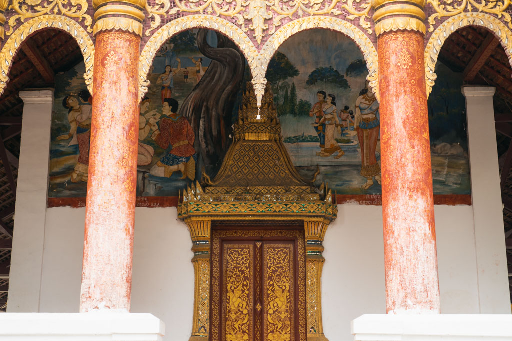 Gold colored artifact and fabric art inside a pagoda in Laos.