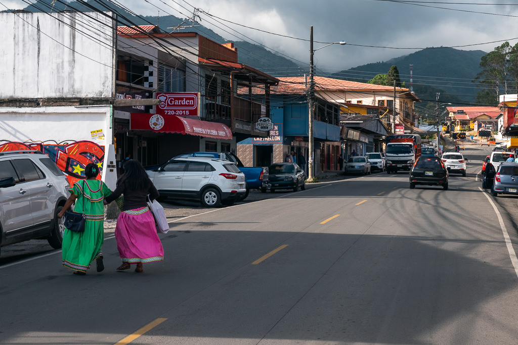 Street in Boquete with a few people and cars.