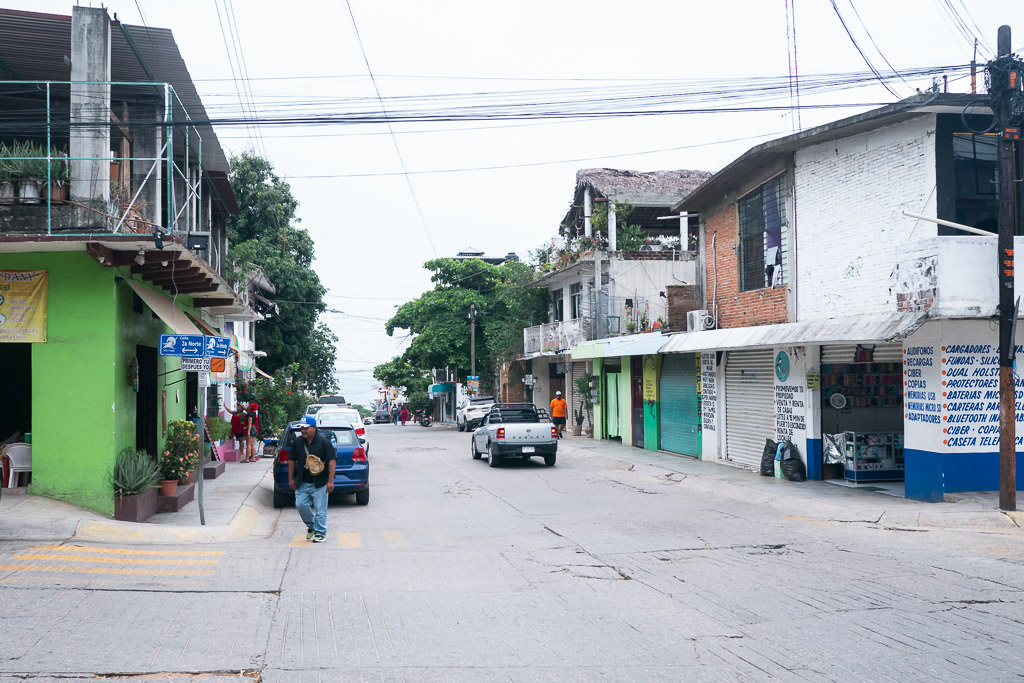 Puerto Escondido's streets stretcheing into the distance, lined with various buildings, some with balconies and shops at street level