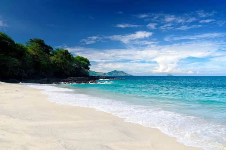 A white-sand beach with blue waters in Bali, Indonesia.