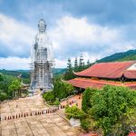 A temple with a giant statue on the mountains of Dalat, Vietnam on a cloudy day.