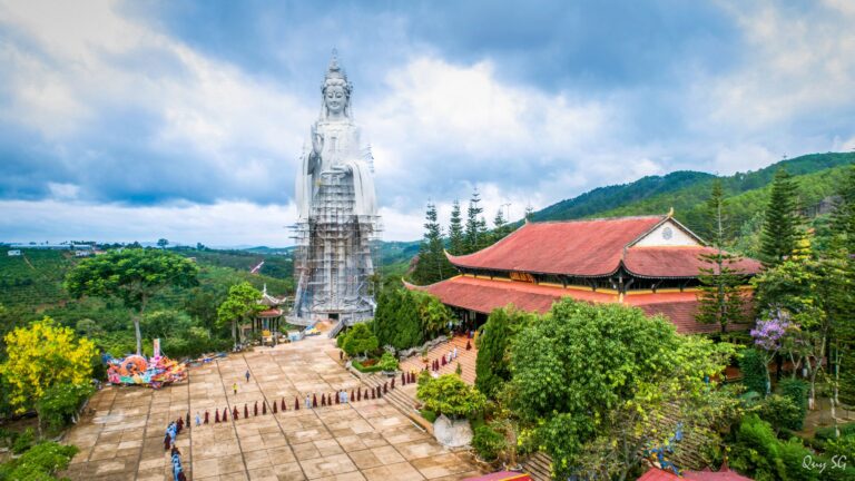 A temple with a giant statue on the mountains of Dalat, Vietnam on a cloudy day.