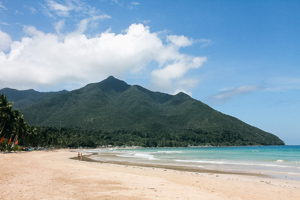 A wide shot captures a serene beach in Palawan