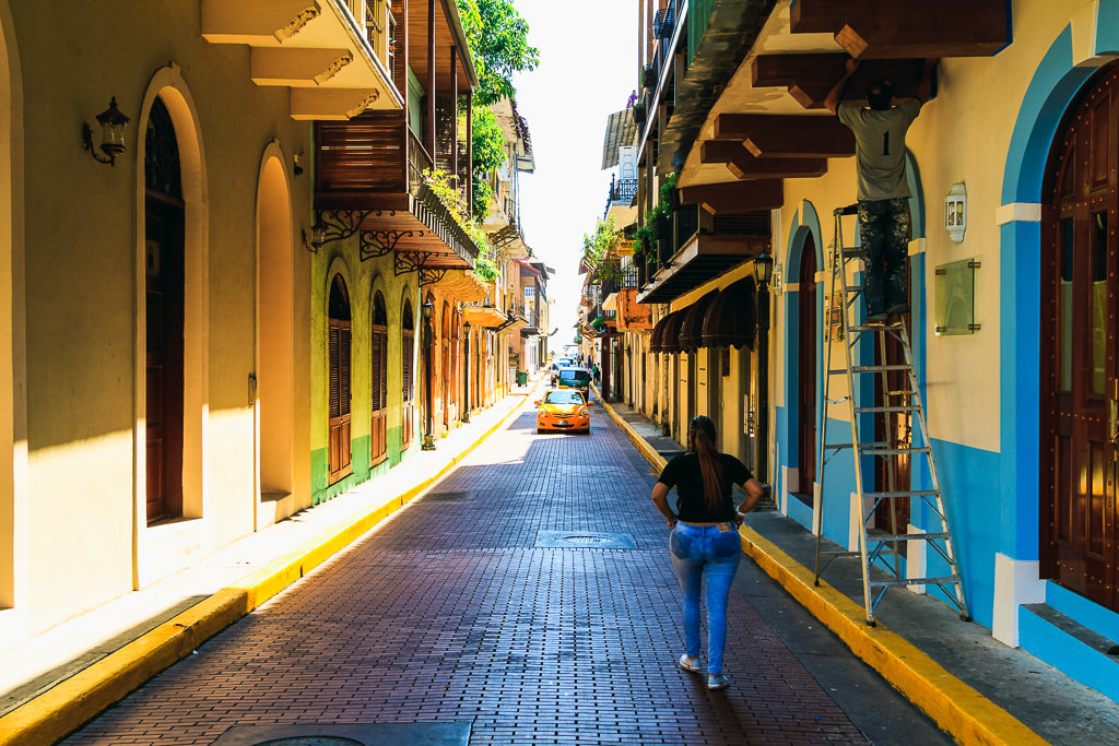 A woman facing backwards walking on a street in Casco Viejo, Panama.