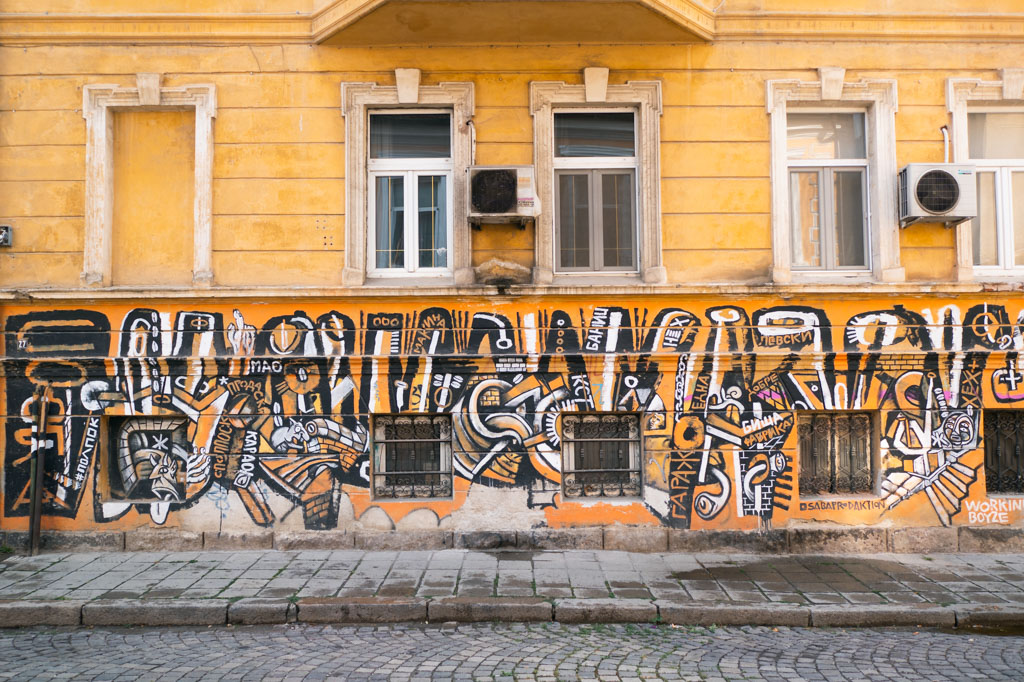 Street art on a yellow building in Sofia, Bulgaria.