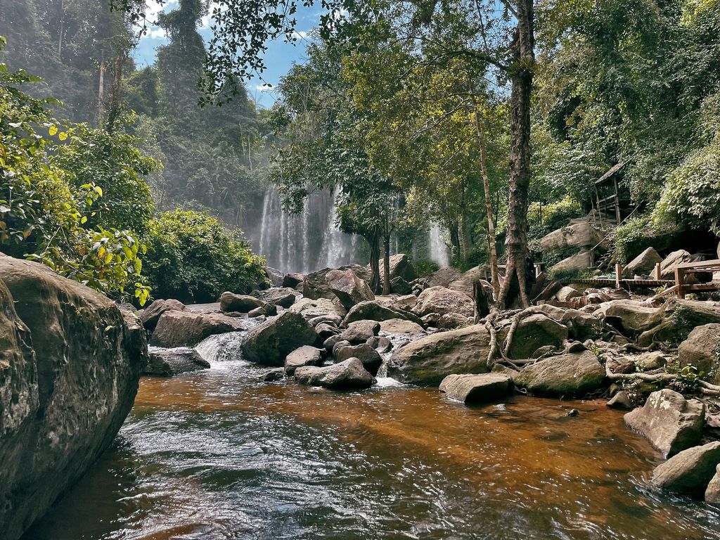 Waterfalls surrounded by rocks and trees in Phnom Kulen National Park, Siem Reap, Cambodia.