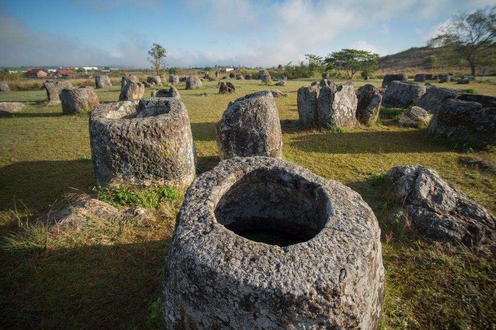 Stone jars scattered around an elevated land in Laos.