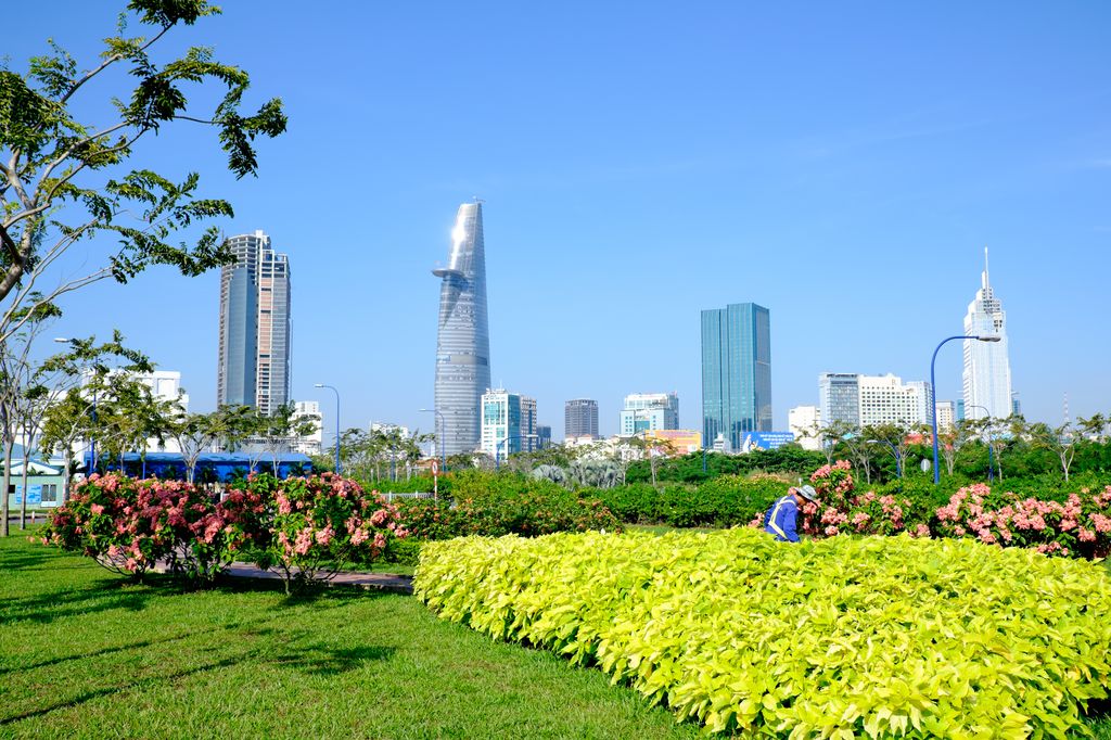 The garden of a park in Saigon, Vietnam with buildings in the background.