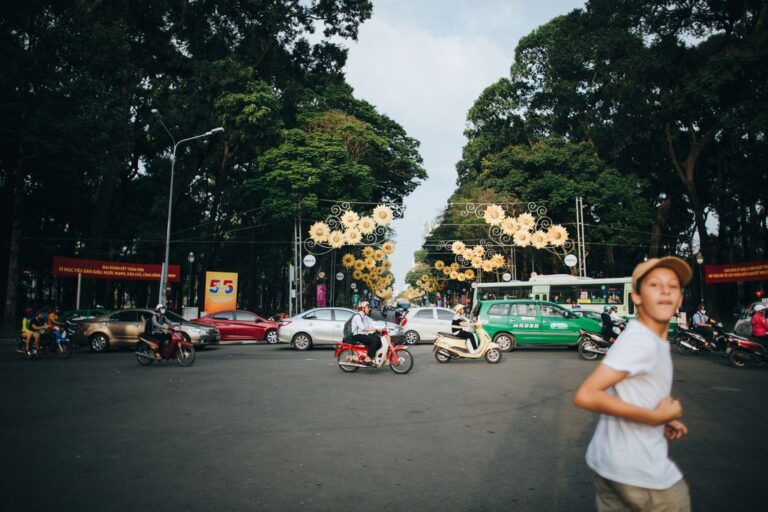 A boy crossing the street and the Saigon road with traffic.