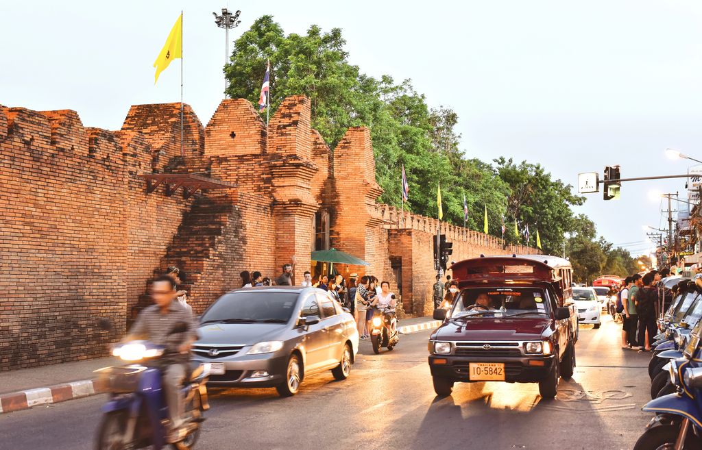 Cars and motorcycles passing by Tha Phae Gate in Chiang Mai, Thailand.