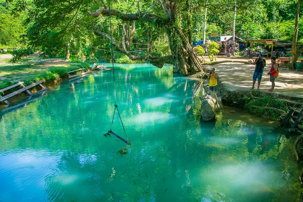 A beautiful green river surrounded by trees in Laos.