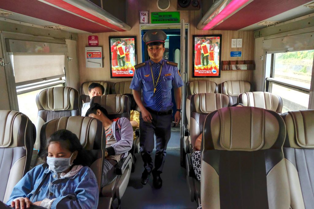 Security walking on the aisle of a train in Vietnam.