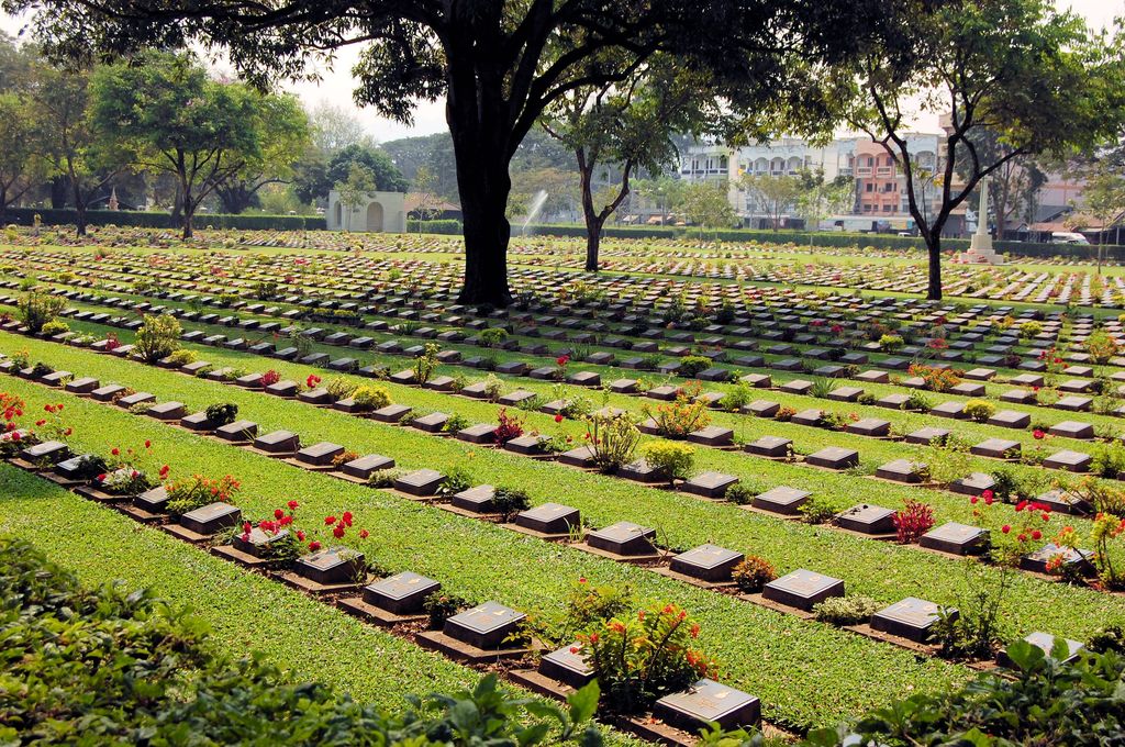 A cemetery with headstones and flowers.