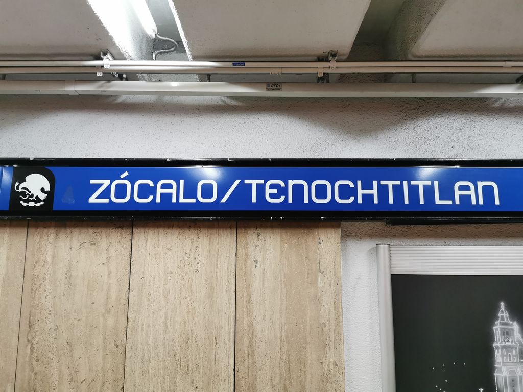A blue sign that says "Zocalo/Tenochtitlan" at a metro station in Mexico City.